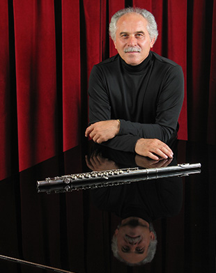 ritratto di uomo con flauto dietro pianoforte